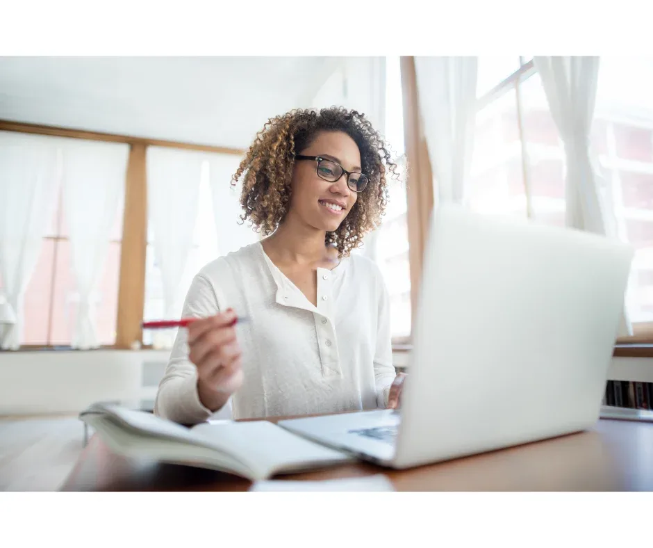 Programa de pós-graduação EaD: dicas para escolher o melhor | Mulher sorridente em frente ao computador estudando | FAVENI