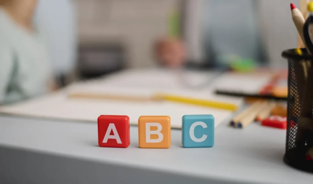 Pós EaD em Alfabetização: quais são as opções? | Foto de três peças coloridas com as letras A B C | FAVENI