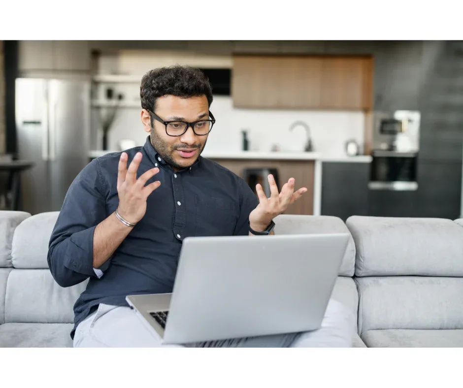 Como o curso de pós-graduação EaD ajuda a mudar de carreira? | Foto de homem indiano com o notebook no colo em uma reunião de negócios | FAVENI