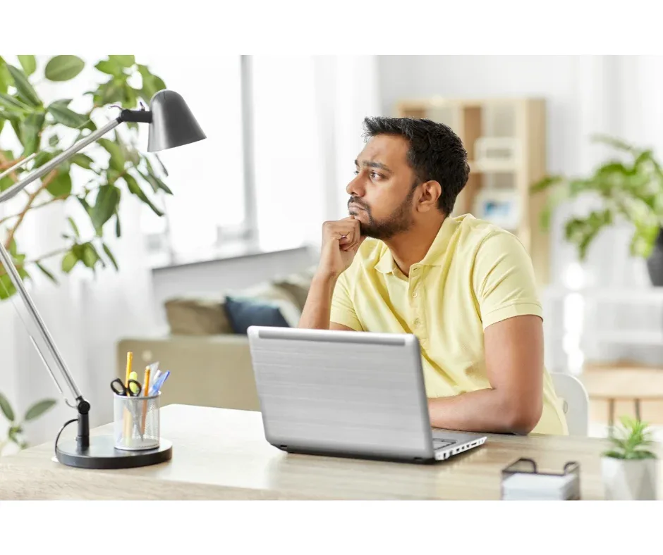 Me formei, e agora? Saiba o que fazer depois da faculdade! | Foto de um homem indiano com expressão pensativa usando o notebook | FAVENI