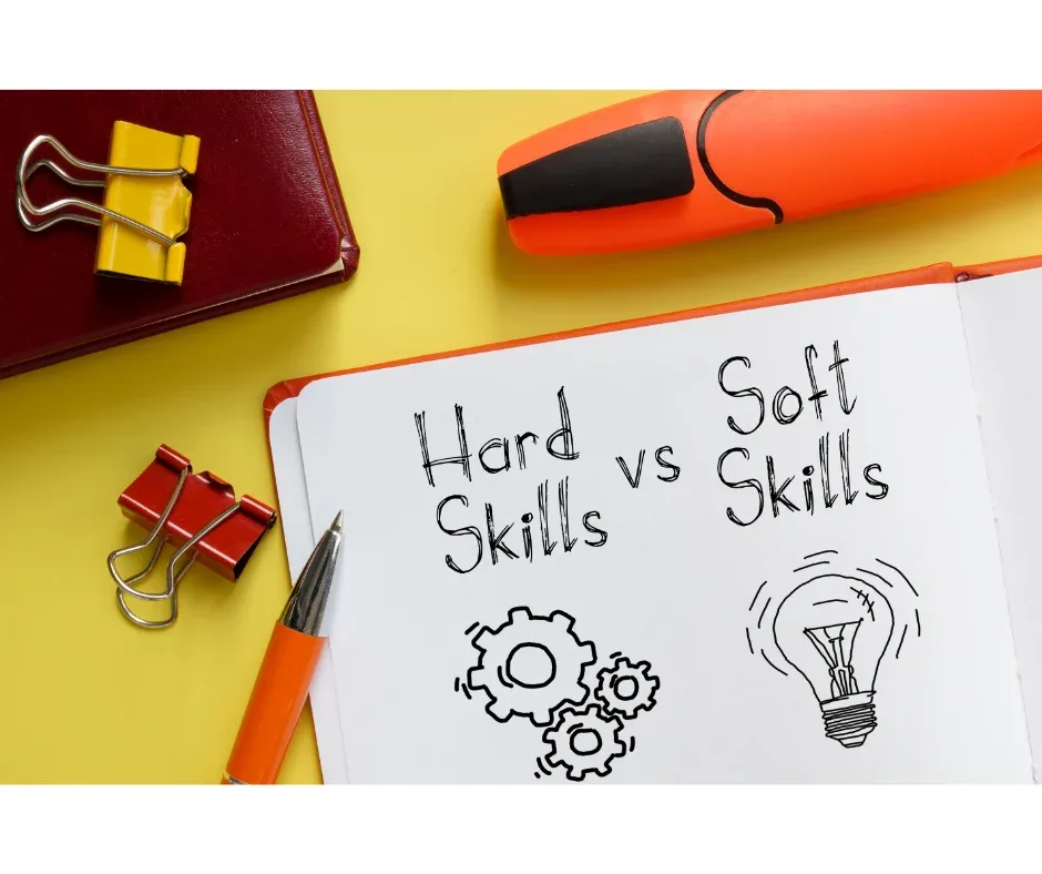 Qual é o papel da pós EaD na requalificação profissional? | Foto de uma mesa com canetas, marca texto e um caderno aberto escrito ‘’hard skills vs soft skills’’ | FAVENI