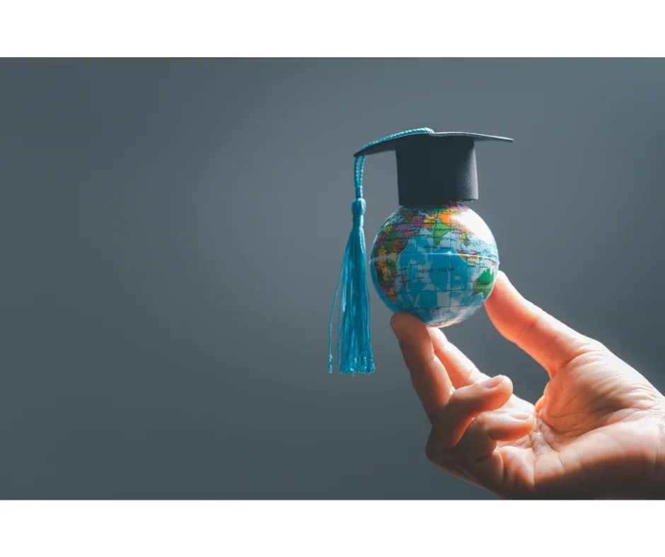 Curso EaD oferece diploma com reconhecimento internacional? | Uma mão segurando um globo com um capelo | FAVENI|Curso EaD oferece diploma com reconhecimento internacional? | Foto de um capelo e um diploma em uma mesa de computador | FAVENI