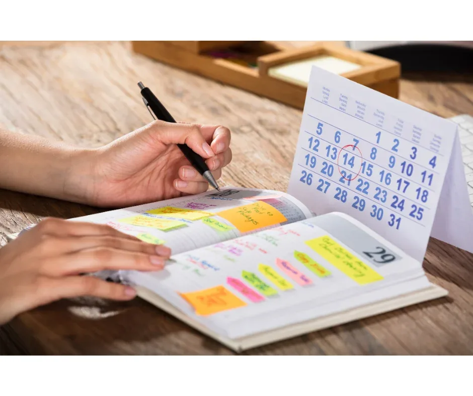 Flexibilidade na pós-graduação EaD: como gerenciar o estudo? | Pessoa anotando compromissos em uma agenda olhando um calendário | FAVENI|Flexibilidade na pós-graduação EaD: como gerenciar o estudo? | Homem fazendo anotações na frente do computador | FAVENI